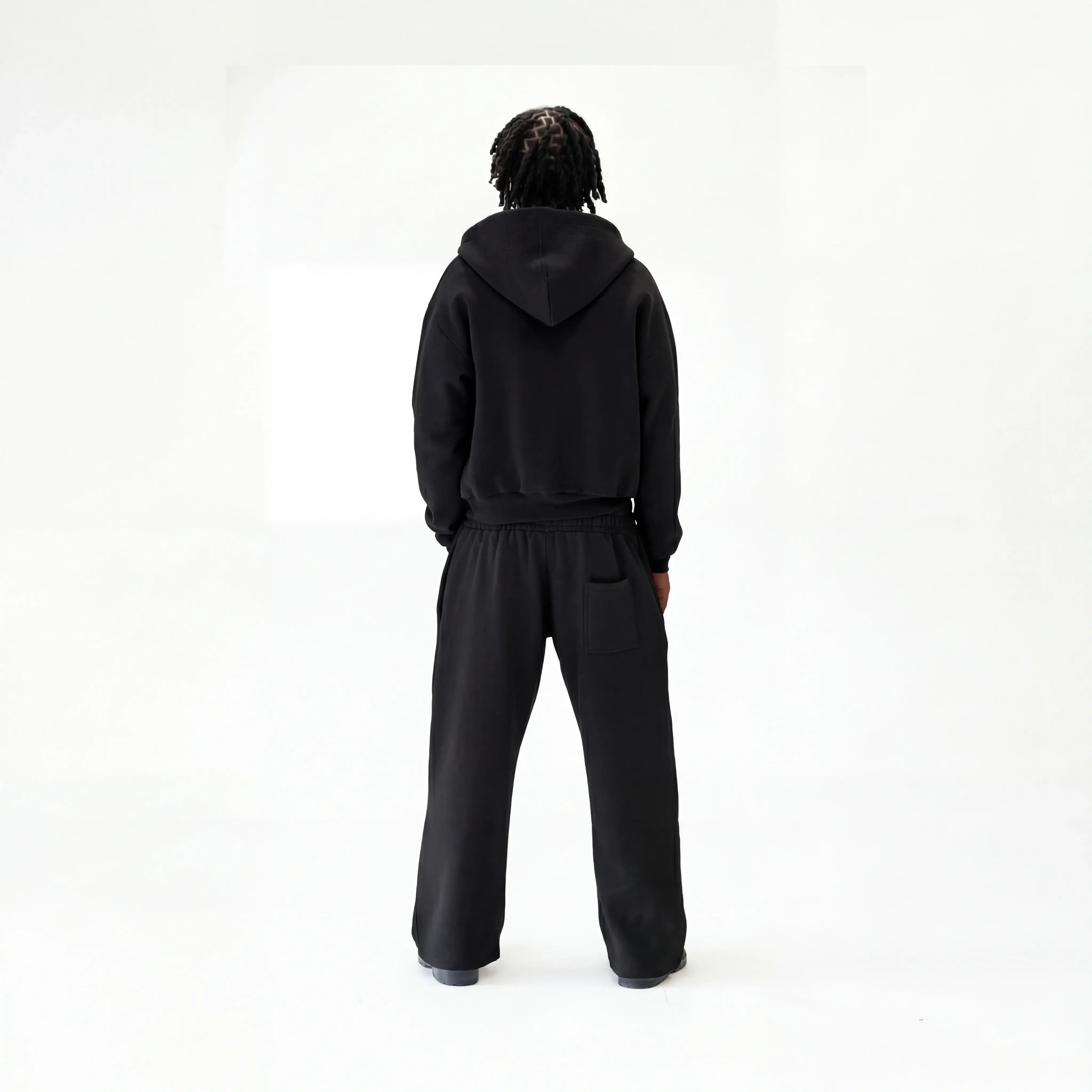 Model wearing black cloud premium tracksuit back shot on white background